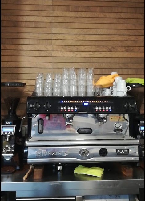 Detalle de la máquina de café del local con tazas y vasos